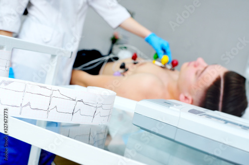 Canvastavla doctor with electrocardiogram equipment making cardiogram test to male patient i