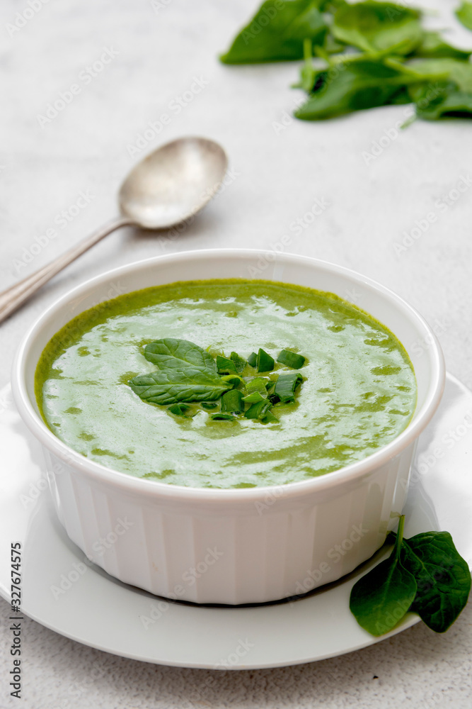 Creamy broccoli soup in a white bowl, spring healthy green creamy soup. Detox, dieting or clean eating food. Creamy broccoli soup in a white bowl, spring healthy green creamy soup. Detox, dieting or clean eating food.