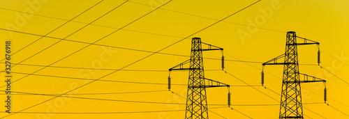Electric power industry. Transmission towers or electricity pylons with golden sky background photo
