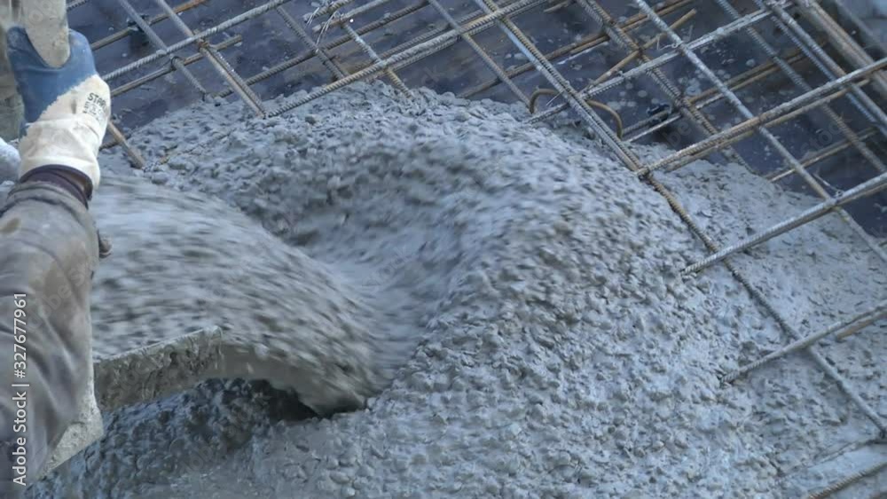 Builders at the construction site pour the surface with a mixture of cement and small gravel to concrete the construction site of a residential building