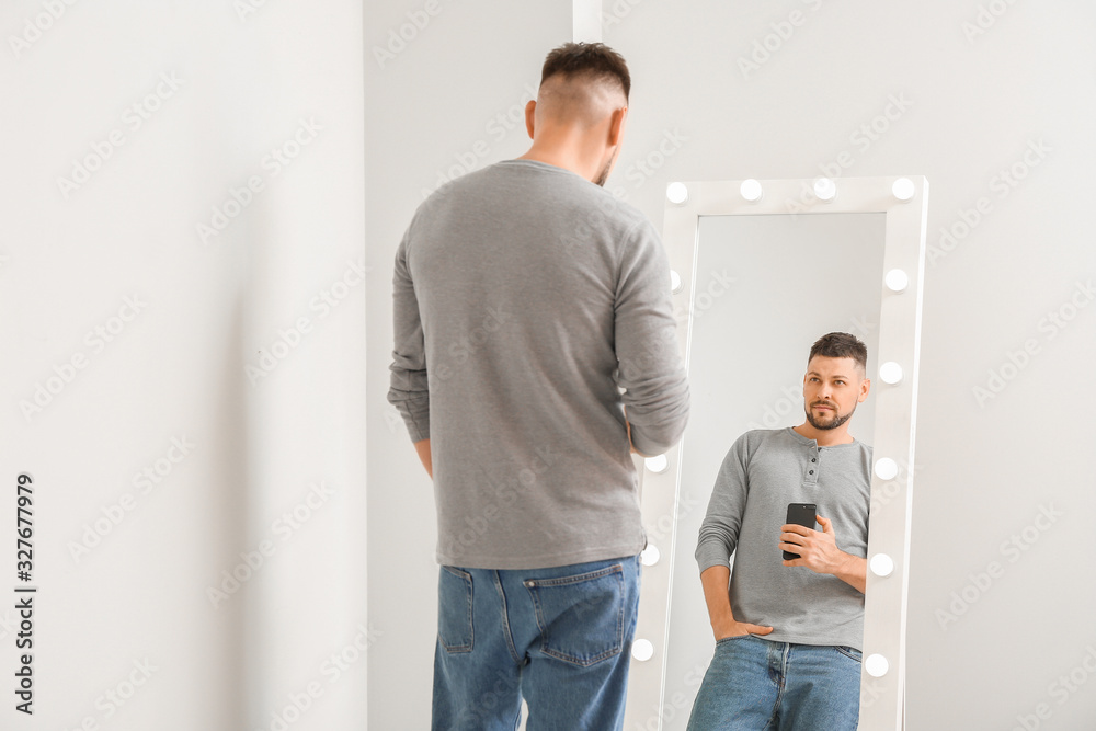 Fototapeta premium Handsome man taking selfie near mirror at home