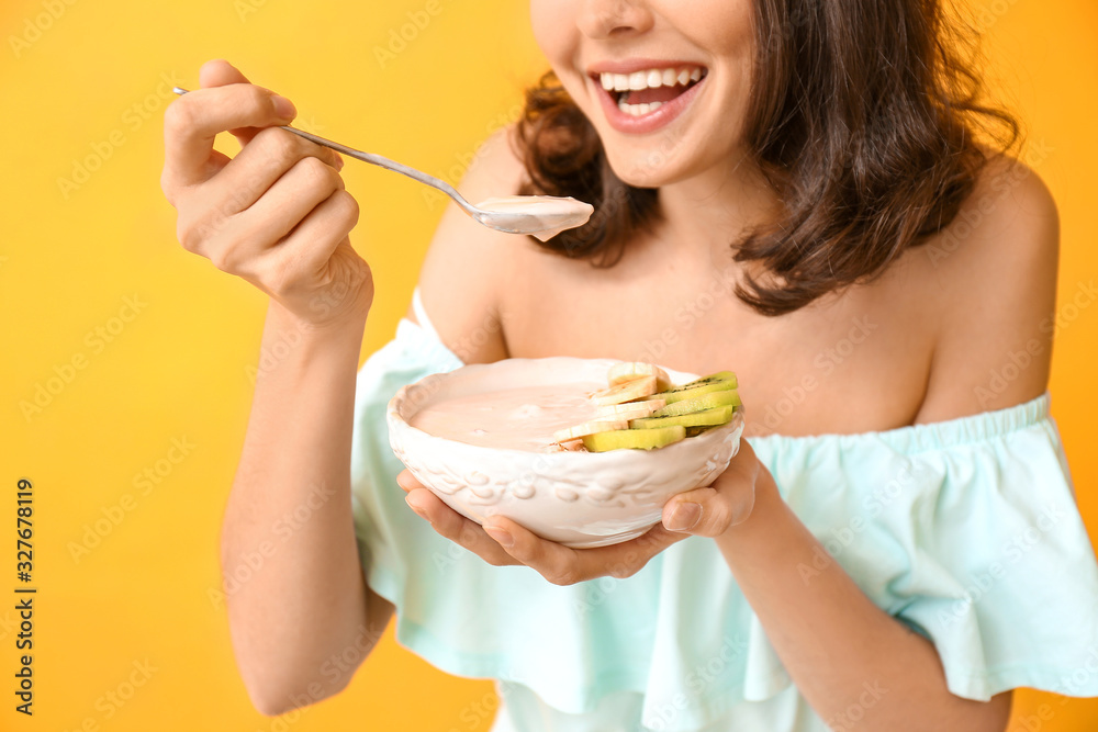 Young woman with tasty yogurt on color background Young woman with tasty yogurt on color background