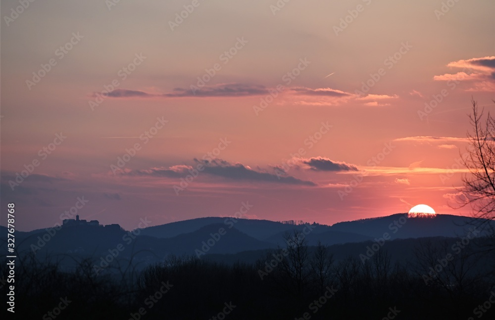 Sonnenuntergang am Horizont mit rot gefärbten Himmel und Burg als Silhouette im Hintergrund (Wartburg ) 