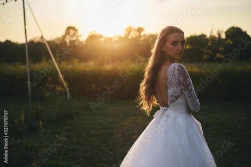 Wallpaper Mural Beautiful young woman in a white wedding dress and black boots at sunset is photographed. Torontodigital.ca
