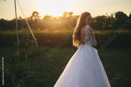 Wallpaper Mural Beautiful young woman in a white wedding dress and black boots at sunset is photographed. Torontodigital.ca