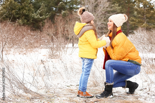 Mother with little daughter in park on winter day