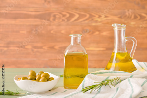 Bottles of tasty olive oil on wooden table