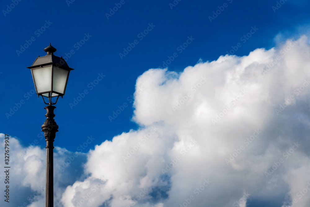 Old fashioned street lamp against beautiful blue sky and white clouds (with copy space)