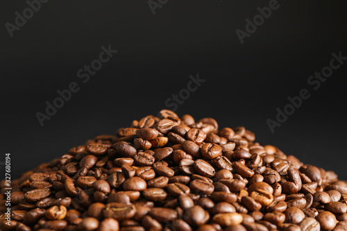 Heap of coffee beans on dark background © Pixel-Shot