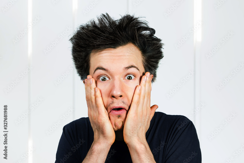Shaggy young guy with long hair surprised with open mouth on a white background Shaggy young guy with long hair surprised with open mouth on a white background