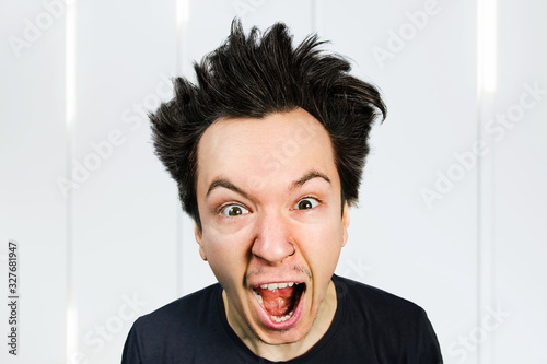 Sad anger young guy look in camera and cry with open mouth and scream, on white background.
