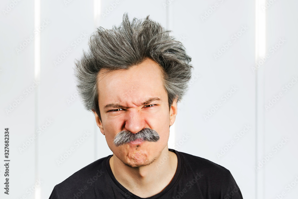 Portrait of jocular aging man wrinkles his nose from sour on his face in Einstein manner. Portrait of jocular aging man wrinkles his nose from sour on his face in Einstein manner.