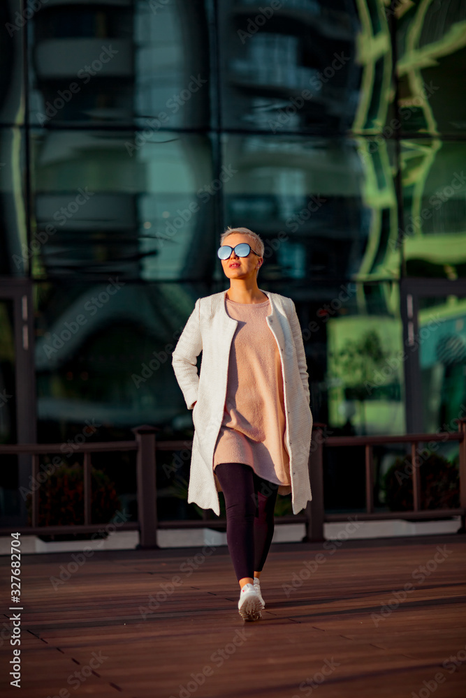Young woman, blonde, walks in sunglasses