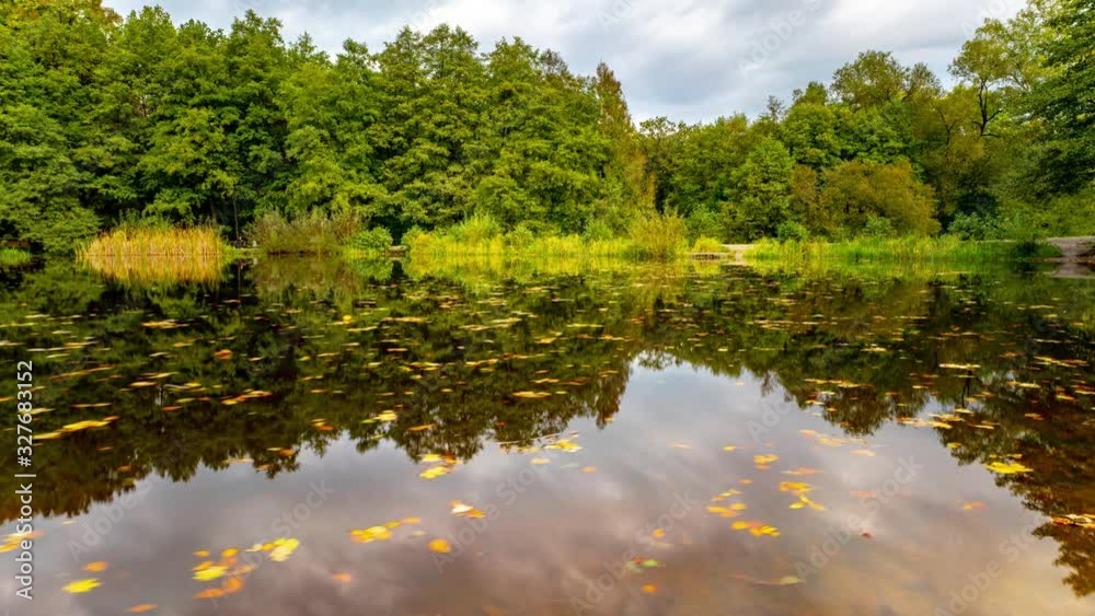 4K time lapse autumn landscape with lake . Colorful foliage park in the fall. Floating leaves and clouds are perfectly reflected in the water. Germany. 4K time lapse autumn landscape with lake . Colorful foliage park in the fall. Floating leaves and clouds are perfectly reflected in the water. Germany.