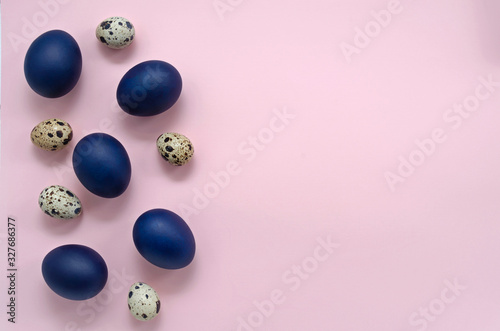 Easter festive romantic concept. classic blue easter eggs and quail eggs on a pink background on the left of the frame with place for text or your drawing photo