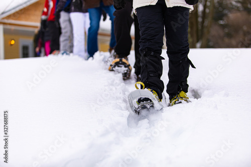 A campsite activity of a small group of people. A crowd moving in the snow using skis. A ways to spend some leisure time in the winter