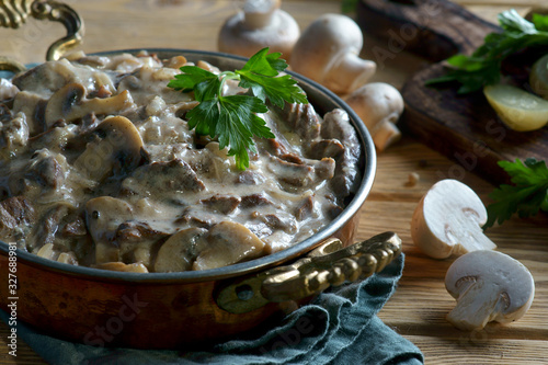 beef Stroganoff in a frying pan on a wooden background