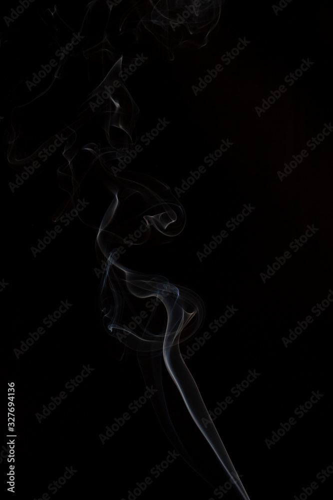 Delicate column of smoke from incense stick isolated on black background, selective focus Delicate column of smoke from incense stick isolated on black background, selective focus