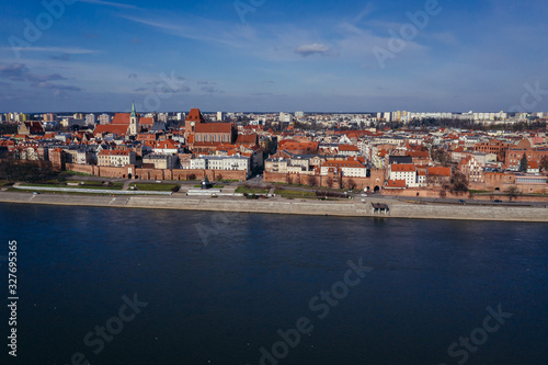 Drone view of historic part of Torun city over Vistula River in Poland with St John the Baptist Cathedral and Church of Holy Spirit