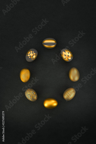 Eight luxury easter Eggs with different patterns in gold lying in an egg shape on a dark textured background. Copy space available photo