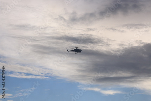 A silhoutte of a helicopter against the evening sky