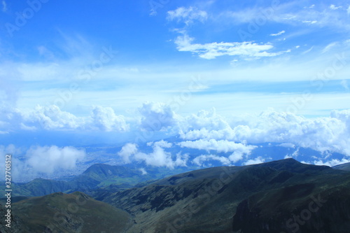 An andean mountain ridge with a stunning cloudscape and bright blue sky