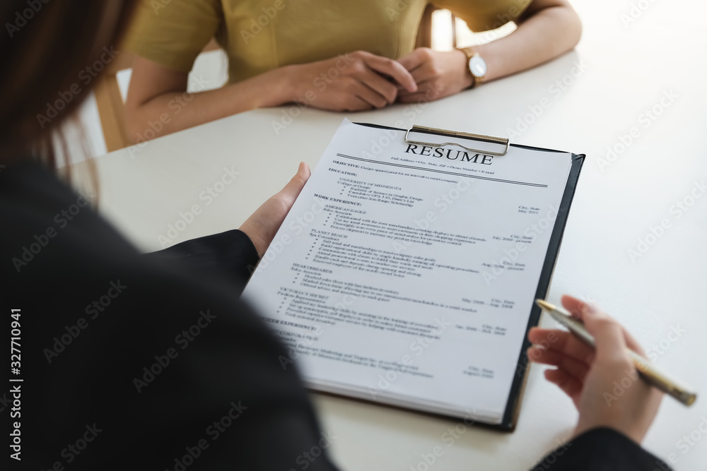 job interview in office concept, focus on resume paper, employer reviewing good cv of prepared skilled applicant, recruiter considering application or hr manager making hiring decision. job interview in office concept, focus on resume paper, employer reviewing good cv of prepared skilled applicant, recruiter considering application or hr manager making hiring decision.