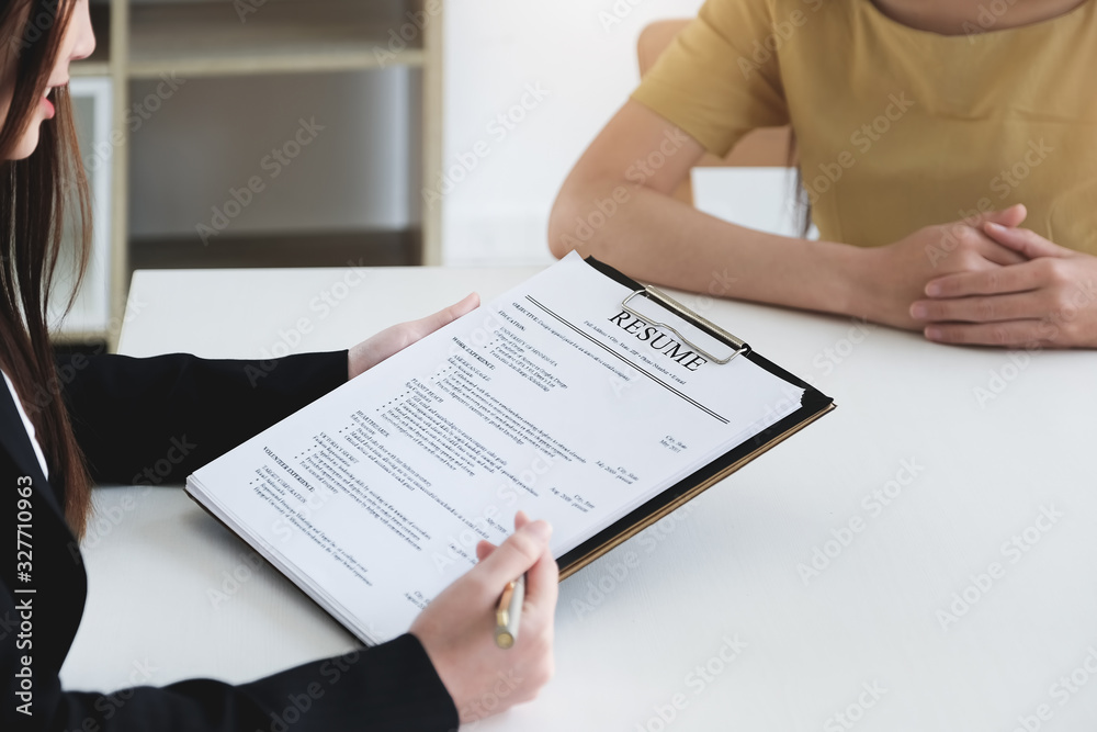 job interview in office concept, focus on resume paper, employer reviewing good cv of prepared skilled applicant, recruiter considering application or hr manager making hiring decision. job interview in office concept, focus on resume paper, employer reviewing good cv of prepared skilled applicant, recruiter considering application or hr manager making hiring decision.