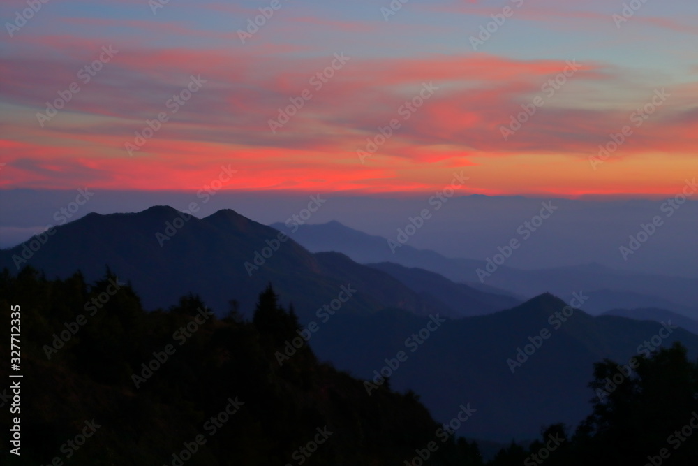 landscape mountain forest in the mist with sunset sky in mystic nature