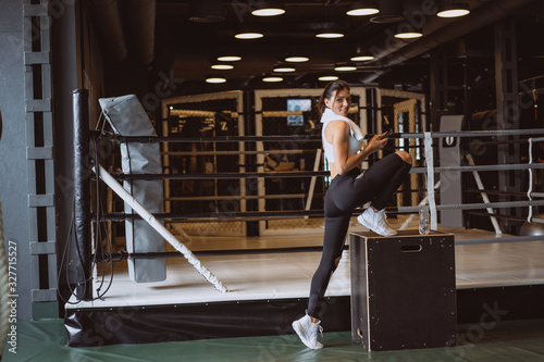 Beautiful young woman in sportswear posing on camera in the gym