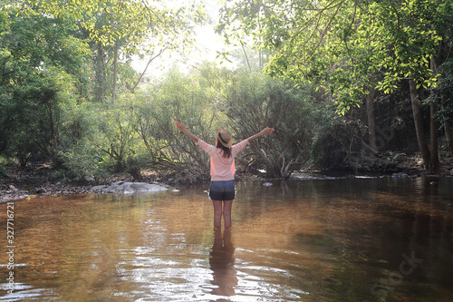 Female traveler relaxing among beautiful nature park. Relaxation and travel concept