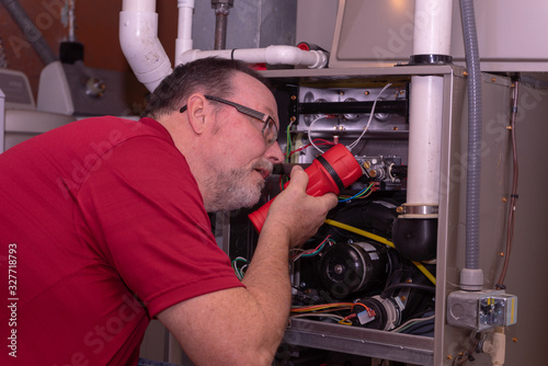 Tech Looking For Issues With Furnace  Red Shirt 