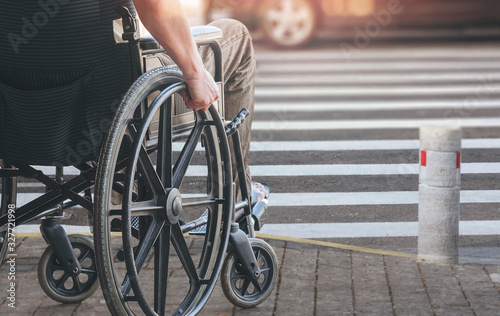 Disablee man on wheelchair crossing the road. photo