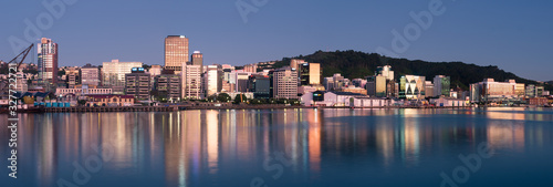 Wellington city buildings and skyline reflected in the harbour at sunrise on a perfect summer morning. 