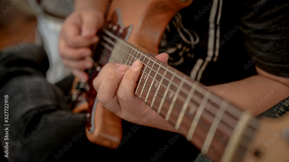 Cropped shot of male musician playing guitar in music instrument