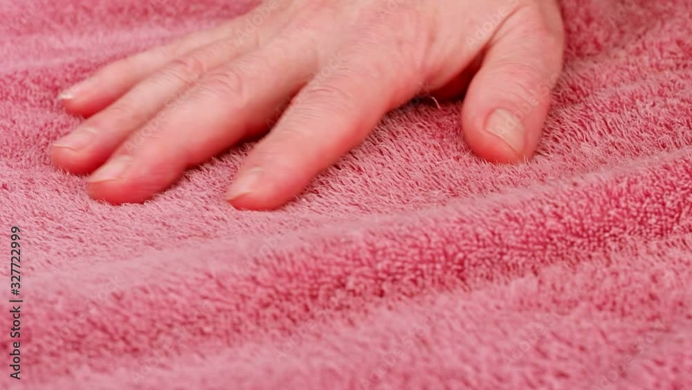 Man's hand strokes the Terry cloth. Close-up of the hand on the background of the fabric texture, macro shot. Fabric of towel, close up. Static camera. Close-up view, full HD