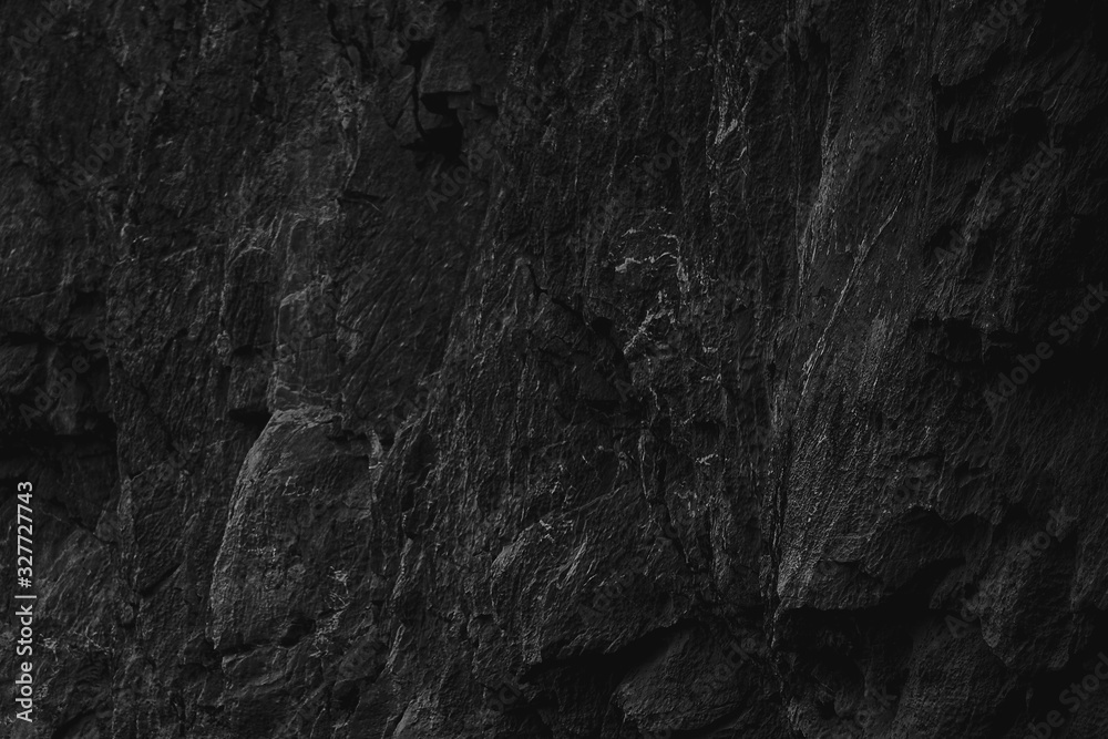 Dark Aged Shabby Cliff Face And Divided By Huge Cracks And Layers. Coarse, Rough Gray Stone Or Rock Texture Of Mountains, Background And Copy Space For Text On Theme Geology. Selective Focus.