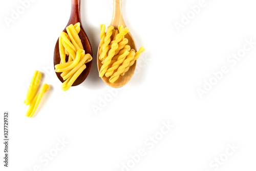 Two types of italian pasta concept. Raw gemelli, casarecce in wooden spoons on white background. Top view, copy space.