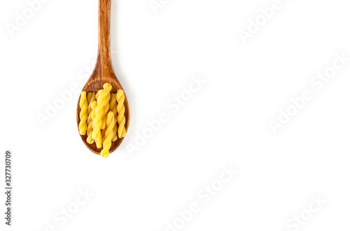 Raw Italian pasta in wooden spoon on white background. Food and drink concept. Top view. Copy Space