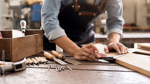 Foto Carpenter working with equipment on wooden table in carpentry shop