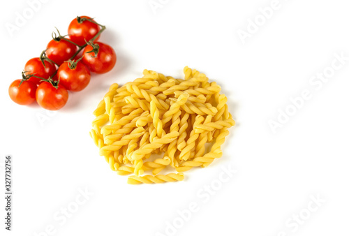 Raw dry Italian pasta witch tomatos isolated on white background. Food and drink concept. Top view. Copy Space