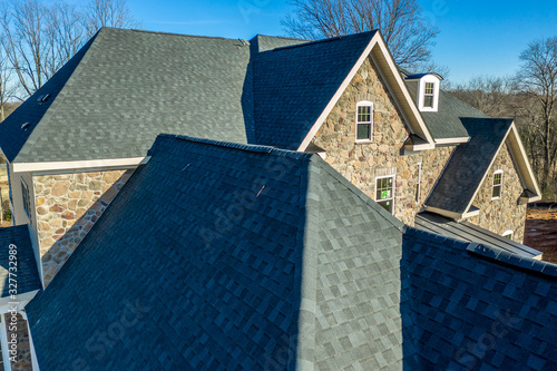 Konstfotografi Aerial close-up view of a modern asphalt shingle roof with classic ridge, left a