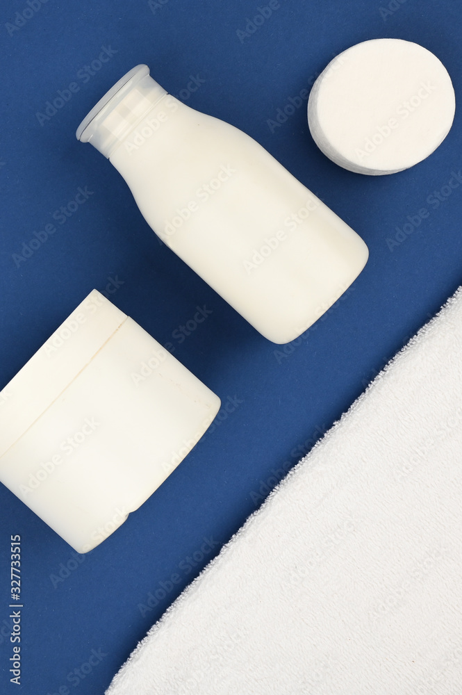 White empty cosmetic tubes on a blue background of 2020. Skin care concept. With copy space. The apartment was lying. View from above. Dermatology, closeup. White empty cosmetic tubes on a blue background of 2020. Skin care concept. With copy space. The apartment was lying. View from above. Dermatology, closeup.