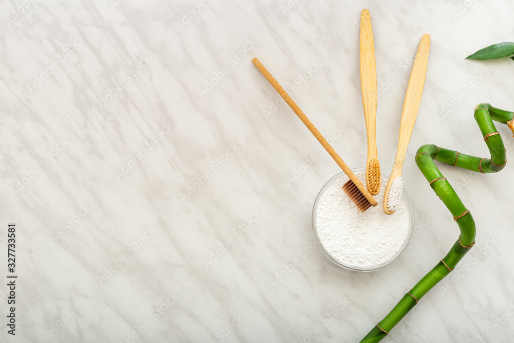 Bamboo toothbrush, bamboo plant dentifrice tooth powder on white marble background.Flat lay copy space.Biodegradable natural bamboo toothbrush.Eco friendly,Zero waste,Dental care Plastic free concept Bamboo toothbrush, bamboo plant dentifrice tooth powder on white marble background.Flat lay copy space.Biodegradable natural bamboo toothbrush.Eco friendly,Zero waste,Dental care Plastic free concept