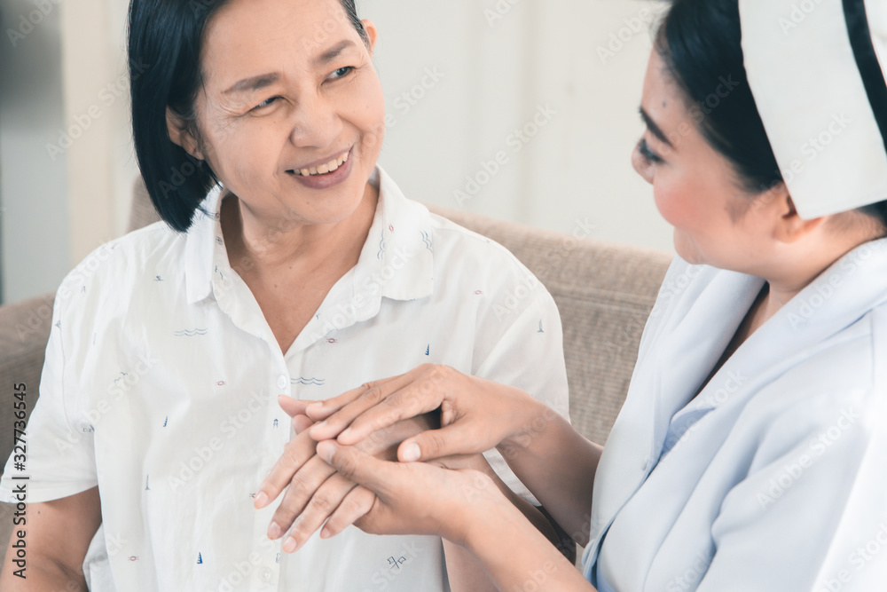 Health visitor and a senior woman during home visit.beautiful Asian nurse taking care of senior patient Health visitor and a senior woman during home visit.beautiful Asian nurse taking care of senior patient
