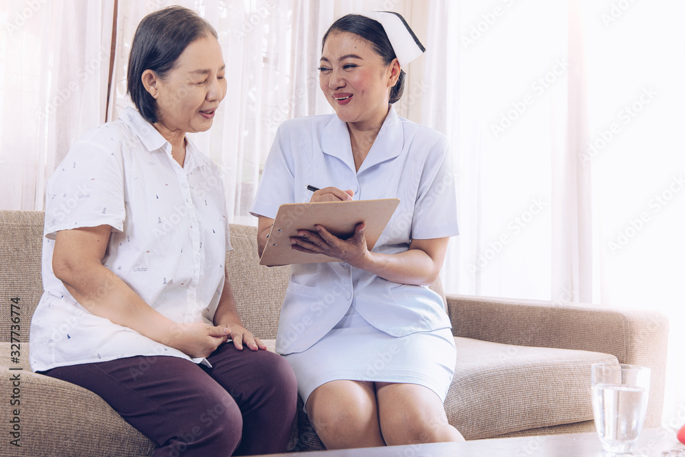 Health visitor and a senior woman during home visit.beautiful Asian nurse taking care of senior patient Health visitor and a senior woman during home visit.beautiful Asian nurse taking care of senior patient