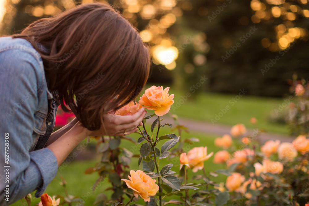 Girl smelling orange roses Girl smelling orange roses