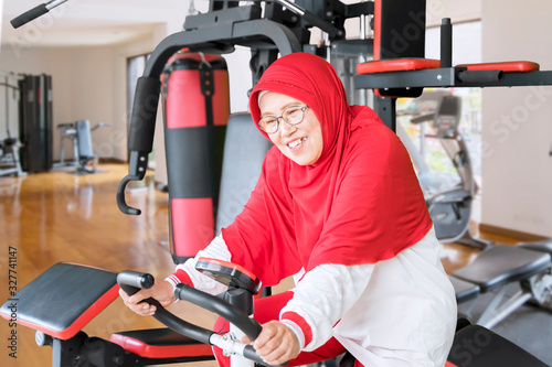 Senior woman doing workout on exercise bike