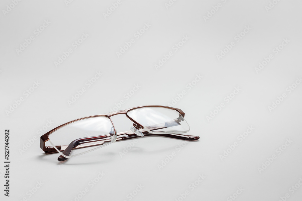 The perspective view of a male medical half-rim eyeglasses with folded temples on a white background The perspective view of a male medical half-rim eyeglasses with folded temples on a white background
