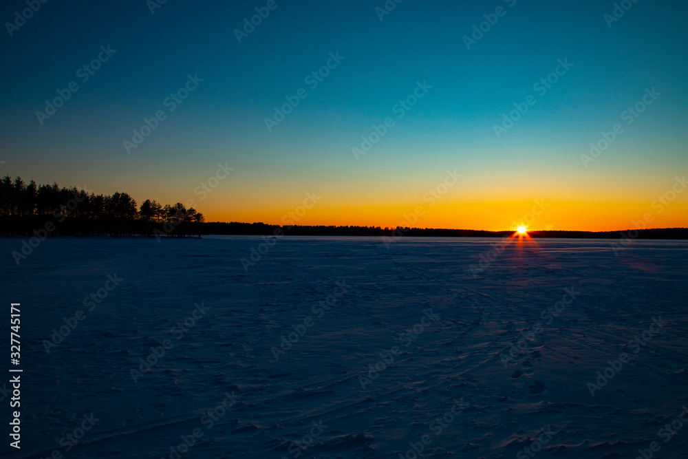 Mystical evening winter landscape. Silhouettes of trees at sunset.